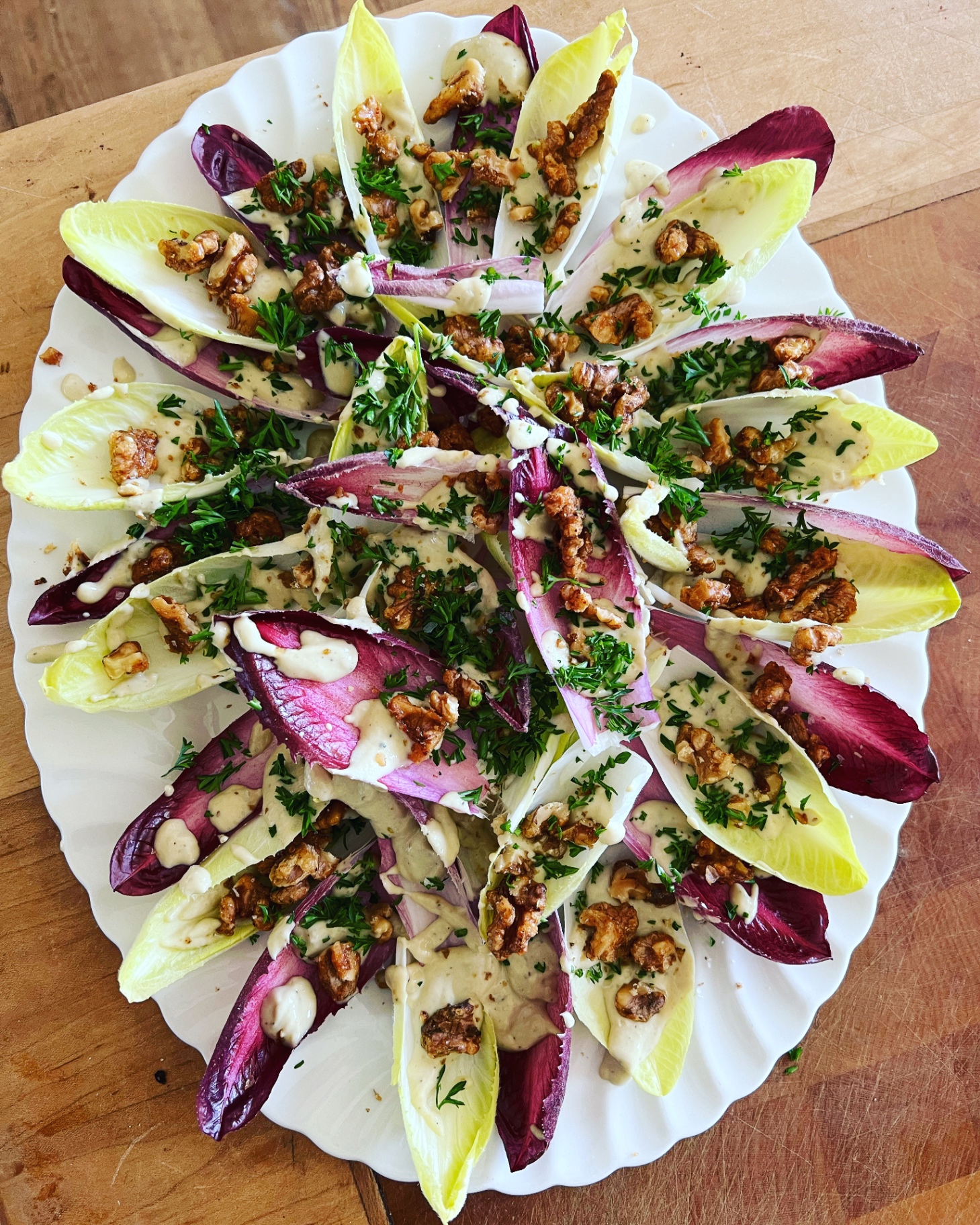 Red and white chicory leaves with candied walnuts, tahini dressing and parsley — a refined salad side at a Lovey Chef private BBQ