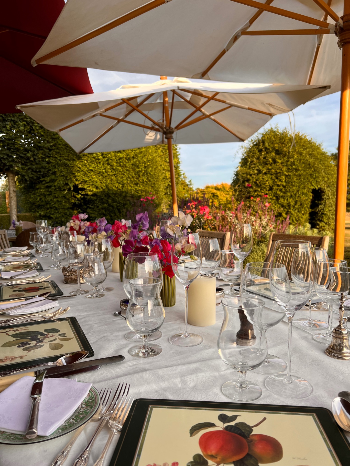 Long garden tablescape with sweet peas and parasols set for a hen night private chef dinner in Bristol